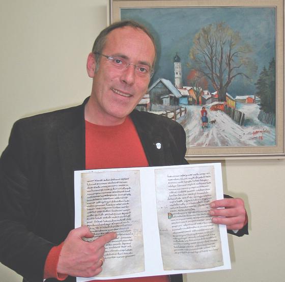 Bürgermeister Stefan Straßmair zeigt auf die Stelle in der Urkundenkopie, an der »ad prunnan« vor 1200 Jahren erstmalig erwähnt ist.	Foto: Boschert