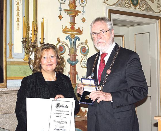 Bürgermeister Michael Sedlmair überreicht Annette Ganssmüller-Maluche die Goldene Ehrenmedaille der Gemeinde Ismaning. 	Foto: Therese Dullinger