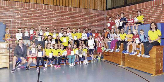 57 Leichtathletik-Kinder des TSV Grasbrunn halten stolz ihre Sportabzeichen in den Händen.	Foto: privat