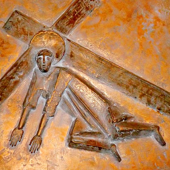 Kunstvolle Bronzeplatten werden betrachtet: Hier der Ausschnitt des 3. Stationsbildes auf dem Kreuzweg  Jesus fällt das erste Mal.	Foto: Verein