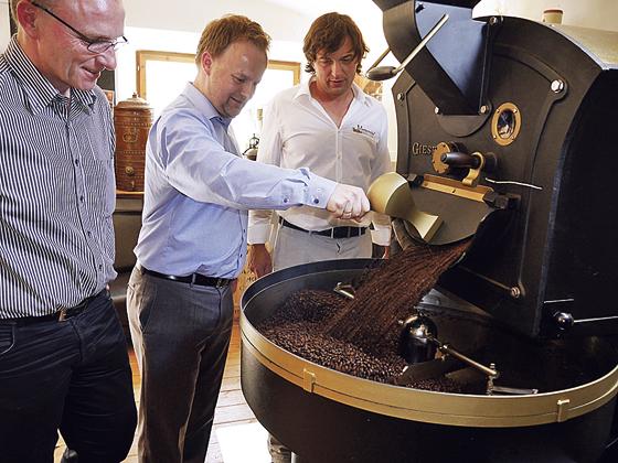 Bürgermeister Hans Fent (v.l.), Robert Niedergesäß und Ralf Heincke vor der Kaffeeröstmaschine. 	F: LRA