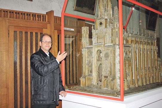 Pfarrer Michael Schlosser vor einem Modell der Mariahilfkirche aus dem Jahre 1841, das derzeit zum 175. Jubiläum des Gotteshauses ausgestellt ist.	Foto: js