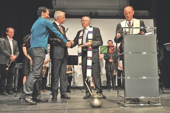 Die beiden Pfarrer Josef Riedl und Hans-Dieter Strack überreichten Bürgermeister Walter Brilmayer und Markus Bachmeier (v. r.) ein Kreuz für den Stadtsaal  als Geschenk. 	Foto: Sybille Föll