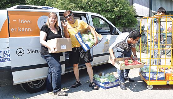 Die 2. Vorsitzende der Aßlinger Tafel, Tanja Adler (l.), hilft den Fahrern, die  Lebensmittelspenden ins Haus zu bringen. Als Zugabe gab es diesmal sogar  Blumen.	Foto: Sybille Föll
