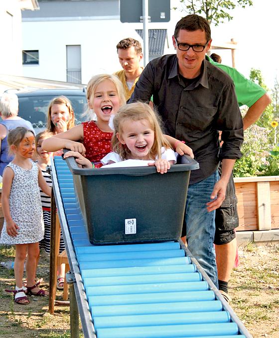 Vorsicht, Papa, ich komme! Das Spielmobil, eine Rodelbahn für die Kinder, war ein Highlight beim Fest.	 Foto: Montessori