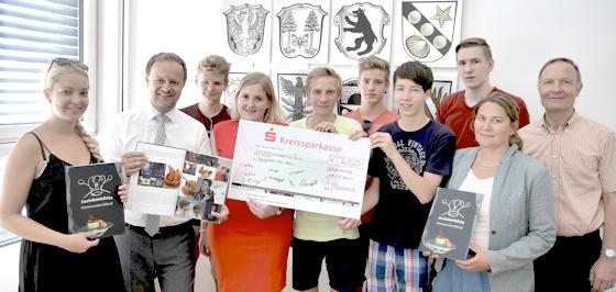Die Schüler des Grafinger Gymnasiums übergeben den Scheck mit dem Erlös von 650 Euro aus ihrem Kochbuch-Projekt an den Landrat.	Foto: Evelyn Schwaiger