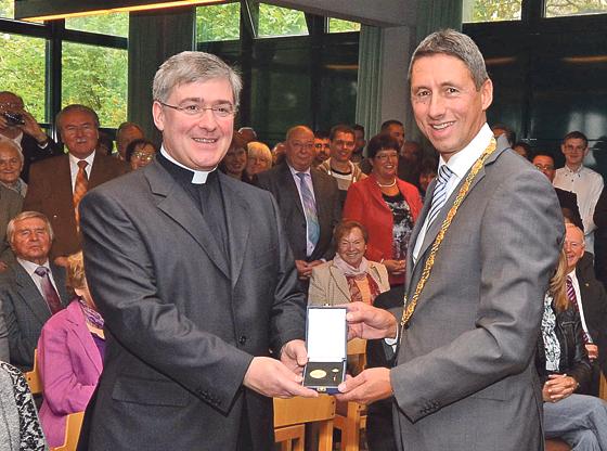 Pfarrer Braun erhielt zum Abschied von Bürgermeister C. Böck die Ehrenmedaille in Gold.	Foto: Gemeinde