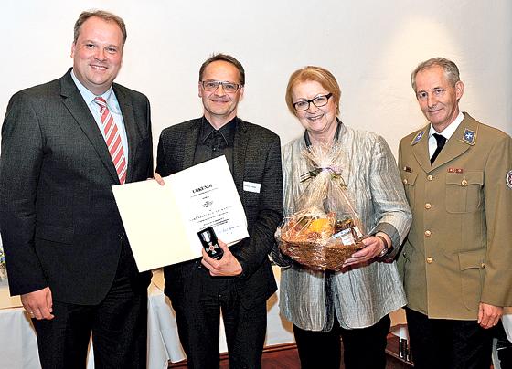 Landrat Christoph Göbel (v. l.) übergibt Johanniter Christoph Scholze das Ehrenzeichen am Band für 25 Jahre aktive ehrenamtliche Tätigkeit. 	Foto: Landratsamt München