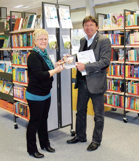 Bürgermeister Albert Hingerl überreichte der Leiterin der Poinger Bücherei, Gertraud Bamberg, symbolisch einen eReader. 	Foto: Gemeinde Poing