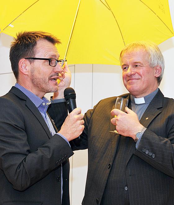 Pfarrer Philipp Wahlmüller (li) begrüßt seinen neuen Kollegen Pater Tadeusz Sobczyk mit dem St. Otto-Schirm. 	Foto: privat
