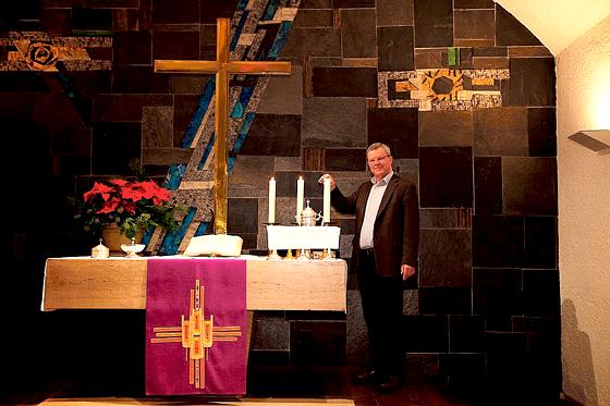 Pfarrer Kauffmann zündet auch an den Weihnachtsfeiertagen in der Friedenskirche die Kerzen am Altar an.	Foto: Benno Steuernagel-Gniffke