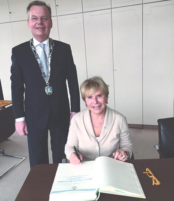 Honorarkonsulin Christa Brigitte Güntermann trug sich ins Goldene Buch der Gemeinde Grünwald ein. Bürgermeister Jan Neusiedl gratulierte.	Foto: VA