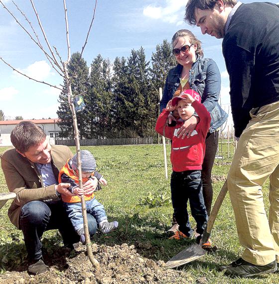 Familie Milutinovic pflanzte einen Zwetschgenbaum für Sohn Leo Marco, der sich gut mit Bürgermeister Andreas Kemmelmeyer (links) verstand.	F.: Gemeinde