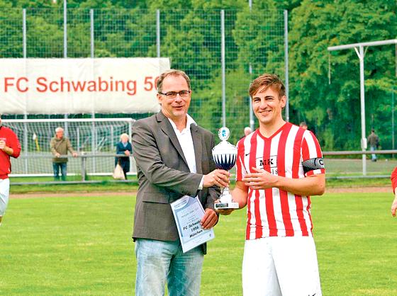 Yannick Krieger nahm die Trophäe für die Kreisligameisterschaft von Bernhard Slawinski, BFV-Kreisvorsitzender München entgegen.	Foto: Verein