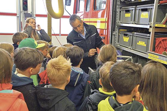 Kommandant Markus Mende erklärt den aufmerksamen Schülern und ihrer Lehrerin Amrei Dettbarn Rettungsspreizer und -schere.	Foto: privat