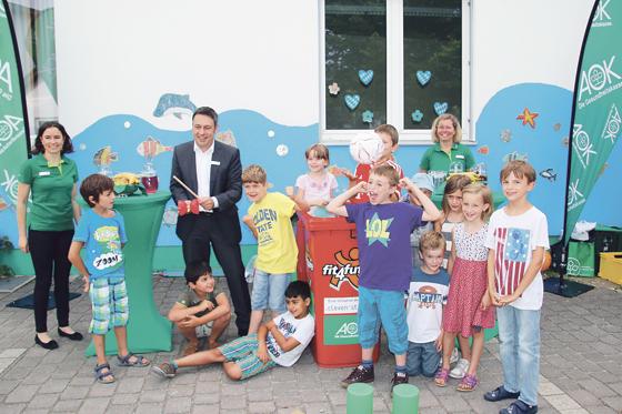 AOK Geschäftsführer Bernhard Frey (mitte) übergab Mitte Juli die neue Spieltonne an die Baldhamer Grundschule.	Foto: aok Bayern
