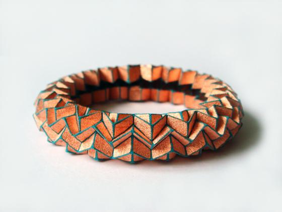 Dieses Armband von Tine de Ruysser sieht aus, als wäre es aus Papier. Die Falttechnik folgt tatsächlich dem japanischen Origami, aber statt Papier hat die belgische Künstlerin hier vergoldetes Silber und Polyester verwendet.	Foto: VA