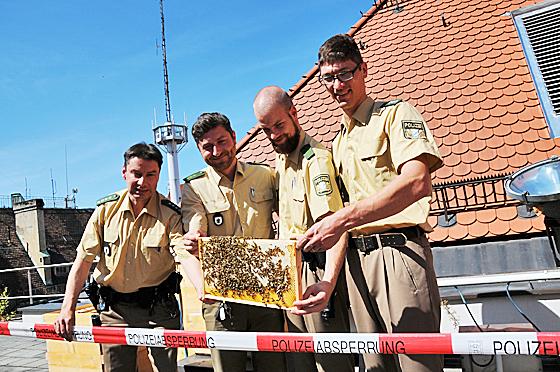 So funktioniert das Zusammenleben: Die Freizeit-Imker in Uniform geben den Bienen Lebensraum, die Bienen produzieren Honig.   Foto: Polizei München