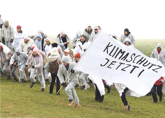 Die weiß gekleideten Teilnehmer des Gipfelmobs färbten den Gipfel des Olympiabergs weiß, um für verbindliche Klimaziele in Paris zu demonstrieren.	Foto: Green City, Tobias Hase
