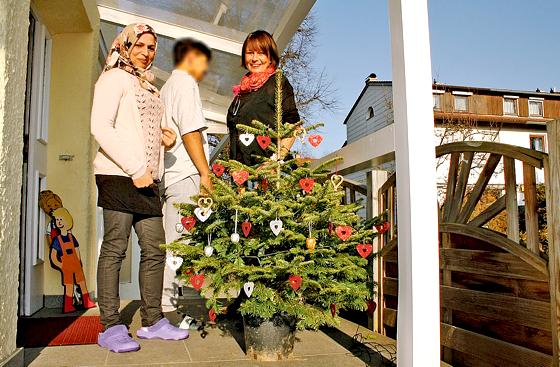 Hauswirtschafterin Atefi Sultani (v.l.), Hassan und Einrichtungsleiterin Bettina Wagner haben gemeinsam mit den Bewohnern die Flüchtlingsunterkunft weihnachtlich dekoriert. 	Foto: js