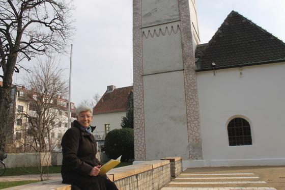 Anna Schneid vom Förderverein Alte St. Georgskirche freut sich über den neugestalteten Platz an der Kirche. Kleines Foto: Neben den Außenmauern wurden auch die früheren Sitzbänke markiert.	Fotos: ch