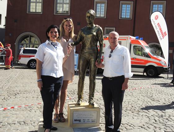 Julia Seiche-Nordenheim, Kickboxweltmeisterin Christine Theiss und Joachim Wolbergs (v.l.) mit der Heldenstatue.	Foto: Helfernetz Bayern