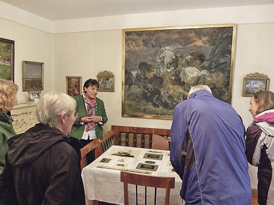 Museumsleiterin Dr. Heike Kronseder erklärt die Scherenschnitte im Biedermeiersalon des ehemaligen Wohnhauses Franz Xaver Stahls. 	Foto: Museum