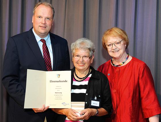 Landrat Christoph Göbel und Ottobrunns zweite Bürgermeisterin Monika Modrow-Lange (r.) gratulierten Mariele Lang.  	Foto: LRA