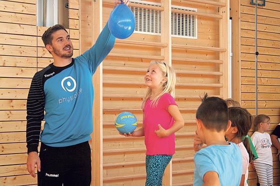 Felix Apelt, Handballtrainer und Abteilungs- leiter beim TSV Ottobrunn, übte mit den Schülern das Balancieren von Luftballons auf Bällen.	Foto: privat