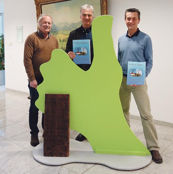 Johann Widmann präsentierte gemeinsam mit Bürgermeister Olaf von Löwis und Andreas Klotz die brandneue Festschrift zum Gemeindejubiläum. 	Foto: hw