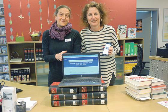 Daniela Raif und Gabriele Oswald vom Grünwalder Bibliotheksteam bieten neben dem Brockhaus in Buchform jetzt auch das geballte Wissen in einer Online-Version an. 	Foto: hw