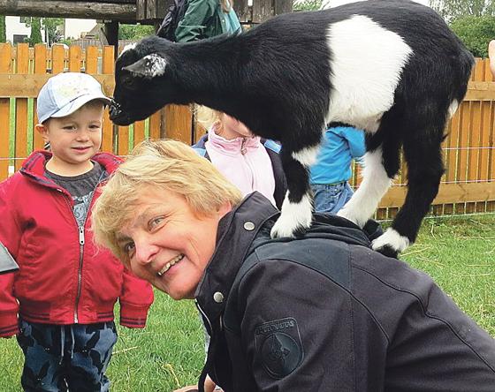 Keine Angst vor kleinen Tieren: Kinderpark-Leiterin Karin  Ossig nimmt das Zicklein huckepackt.	Foto: privat