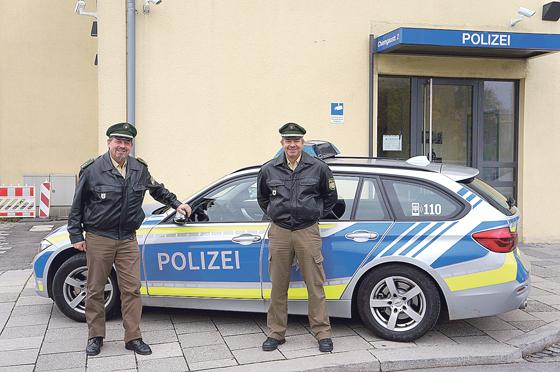 Polizeihauptkommissar Dieter Heumann und Polizeioberkommissar Werner Staude (v. l.) von der PI 23 in der Chiemgaustraße vor einem der neuen Polizei-Einsatzfahrzeuge, die jetzt in Blau und Neongelb gekennzeichnet sind. 	Foto: Heike Woschée