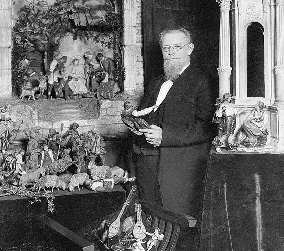 Max Schmederer vor 1900 mit einer Auswahl Krippenfiguren und -architekturen. 	Foto: Bayer. Nationalmuseum München