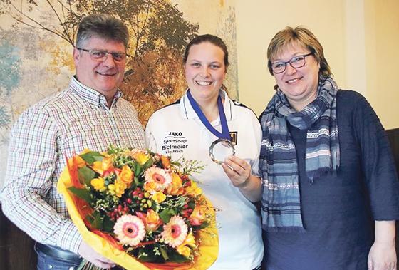 Mit einem Blumenstrauß wurde die frischgebackene Vizeweltmeisterin Franziska Dücker (Mitte) von den Vorständen Sepp Troidl und Michaela Reitmeyer begrüßt. 	Foto: Verein