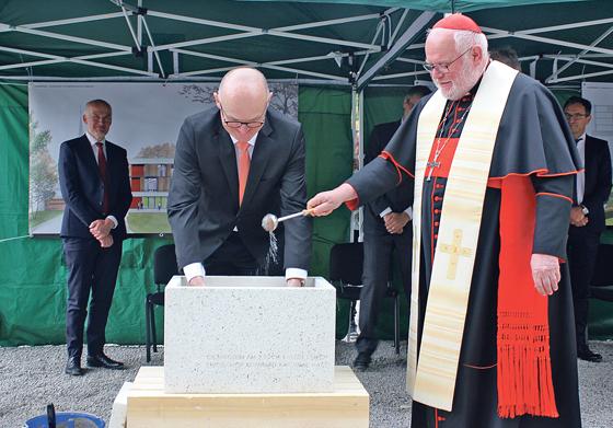 Während der Präsident der Katholischen Stiftungshochschule, Hermann Sollfrank (links), den Grundstein befüllte, übernahm Kardinal Reinhard Marx den Segen.	Foto: bs