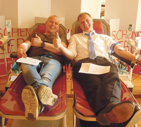 Oberhachings Erster Bürgermeister Stefan Schelle (re.) mit einem anderen freiwilligen Spender bei der Blutspende im Forstnersaal.	Foto: K. Glassl/Rotes Kreuz.