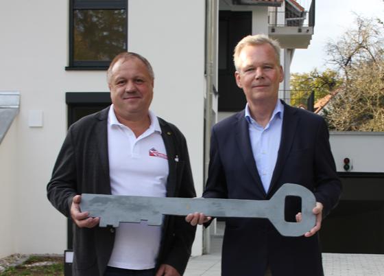 Grünwalds Bürgermeister Jan Neusiedl (r.) bekam vom Bauunternehmer Andreas Kolbinger den offiziellen Schlüssel zum kommunalen Wohnbauprojekt überreicht. Foto: Heike Woschee
