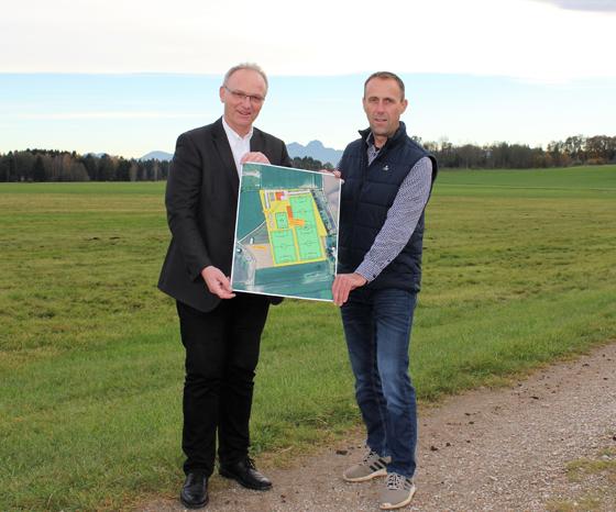 Bürgermeister Hans Fent (rechts) und Geschäftsleiter Wilfried Graupen mit einer Planskizze, wie das Sportgelände einmal angelegt sein könnte. Foto: Gemeinde Aßling