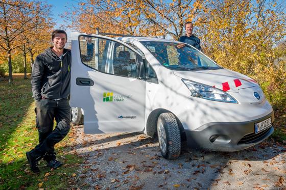 Sportpark-Hausmeister Richard Klijn (links) und Oliver Eberle, Leiter des Sport- und Freizeitpark (rechts) freuen sich über neues E-Auto. Foto: Gemeinde Haar