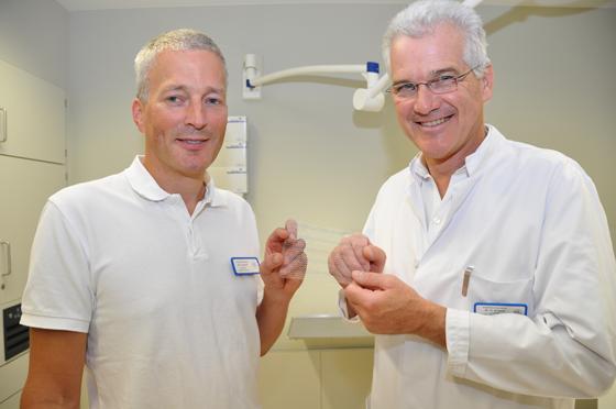 Dr. Stefan Herold und Dr. Peter Kreissl (von links) zeigen ein Kunststoffnetz, das bei Bauchwandbrüchen eingesetzt wird. Foto: kk/sf