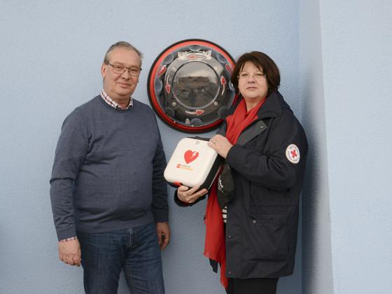 BRK Kreisgeschäftsführerin Elisabeth Seibl-Kinzlmaier installierte zusammen mit Friedrich Peschel einen neuen AED (Automatischer Externer Defibrillator). Foto: BRK Ebersberg