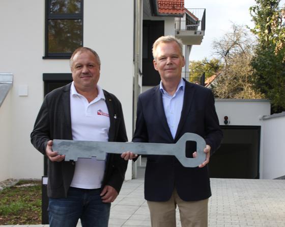 Grünwalds Bürgermeister Jan Neusiedl (r.) bekam vom Bauunternehmer Andreas Kolbinger den offiziellen Schlüssel zum kommunalen Wohnbauprojekt überreicht. Foto: Heike Woschee