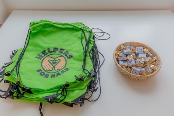  Startgeschenk für die Helpers ist ein leuchtengrüner Helpers-Matchsack und ein süßes Haarer Busserl. Foto: Gemeinde Haar