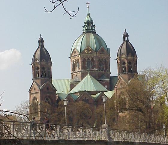 Bauliches Kleinod an der Isar: Blick auf die Kirche St. Lukas mit dem Kabelsteg. Foto: Wikimedia Commons, CC BY-SA 3.0