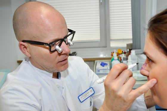 Dr. Timm Engelhardt demonstriert an seiner Kollegin, Assistenzärztin Kerstin Jäger, die Vorbereitung einer Lappenplastik für eine Patientin mit Hautkrebs an der Nasenspitze. Foto: Sybille Föll