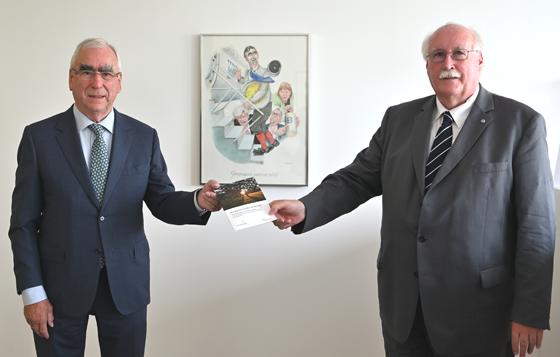 Volksbund-Landesvorsitzender Wilhelm Wenning übergibt die neue Publikation an Bundesminister a.D. Dr. Theo Waigel (links). Foto: Volksbund