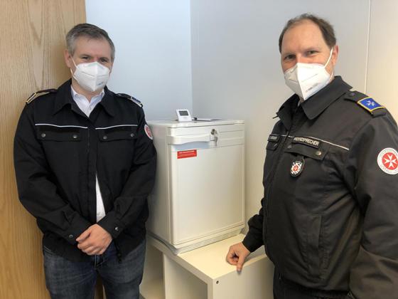 Impfzentrumsleiter Stefan Füger und Pressesprecher Gerhard Bieber stehen vor dem Spezialkühlschrank, der das wertvolle Impfserum enthält. Foto: hw