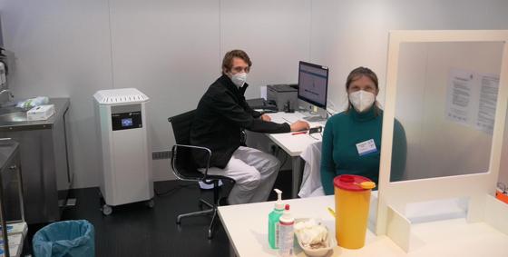 Zwei Mitarbeitende des Impfzentrums in einer der neuen Impfkabinen. Links im Bild die Hygienestation, mit der jede Kabine ausgerüstet ist. Foto: LRA Ebersberg