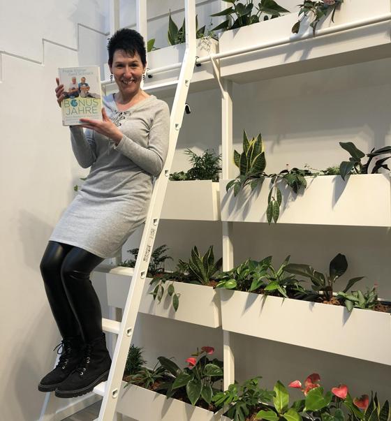 Die Büchereileitung Tanja Keller will hoch hinaus - die sehenswerte Pflanzenwand schmückt den neu gestalteten Seniorenbereich. Foto: Privat